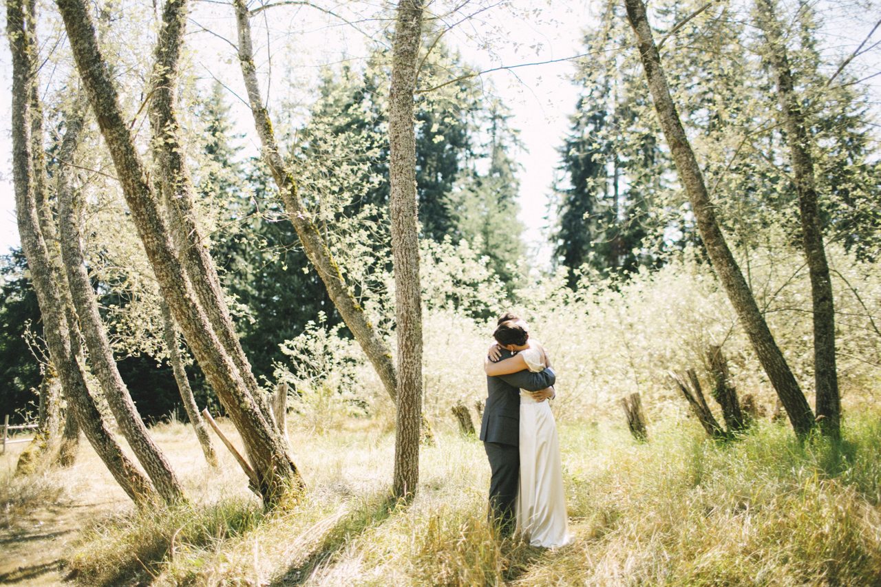 Una sposa e uno sposo che si abbracciano in una foresta