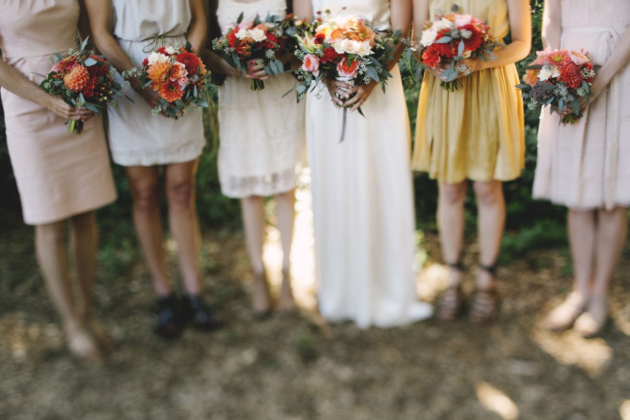 Una sposa e le damigelle che tengono bouquet